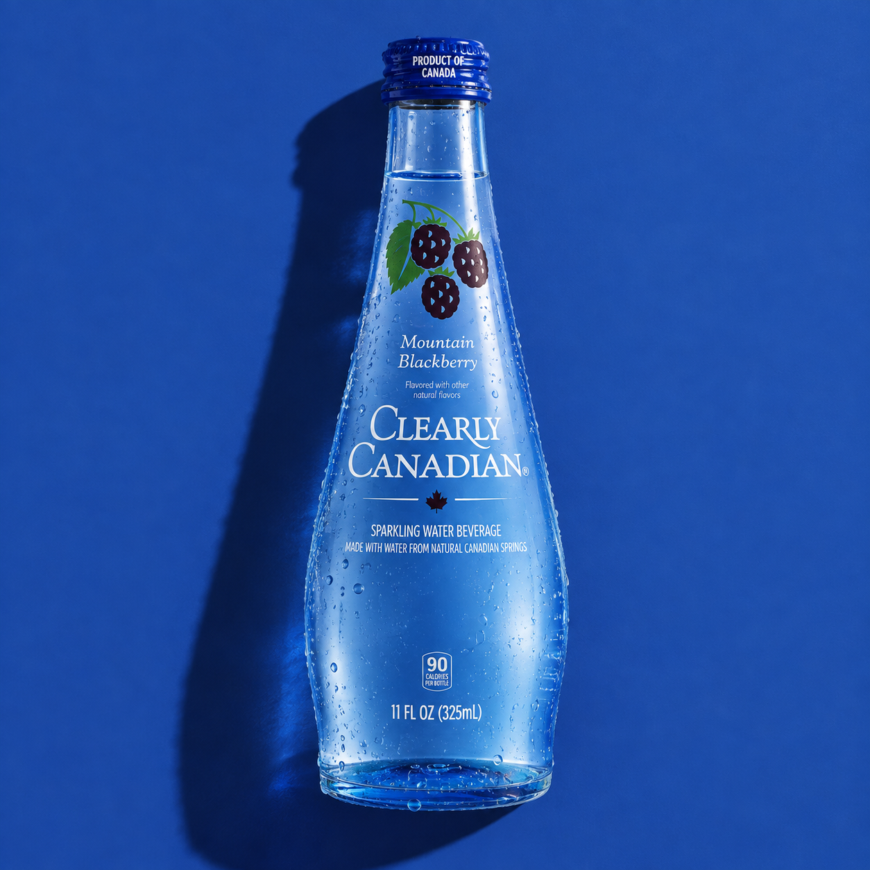 Clearly Canadian Mountain Blackberry glass bottle on blue